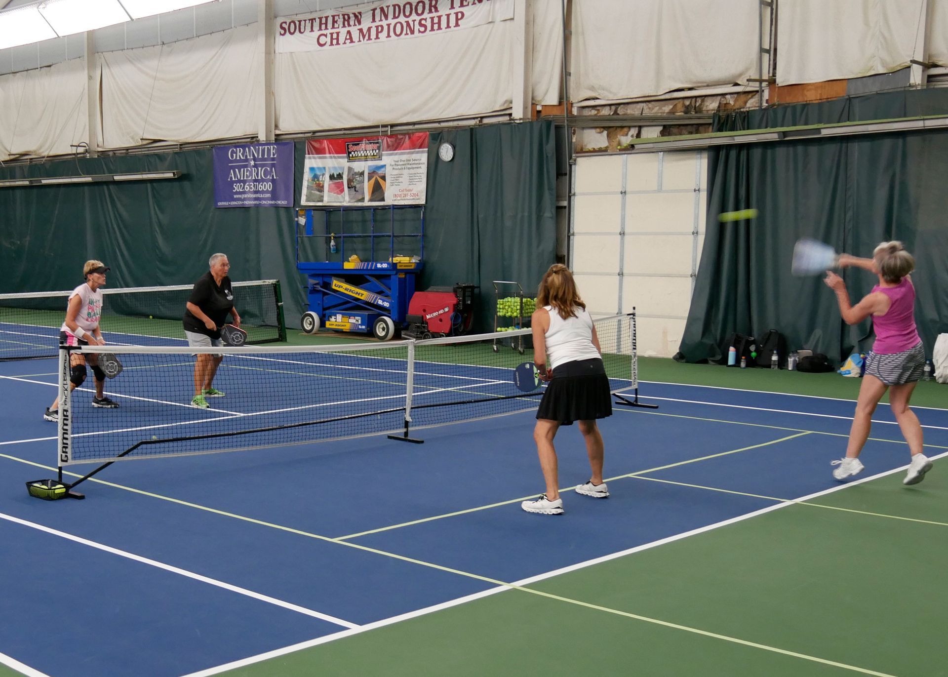 Pickleball doubles teams playing.