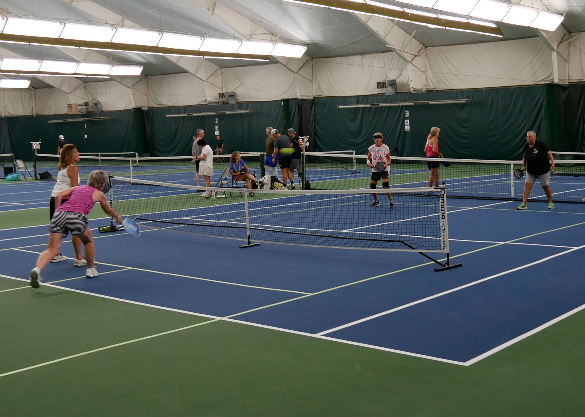 Pickleball doubles teams playing.