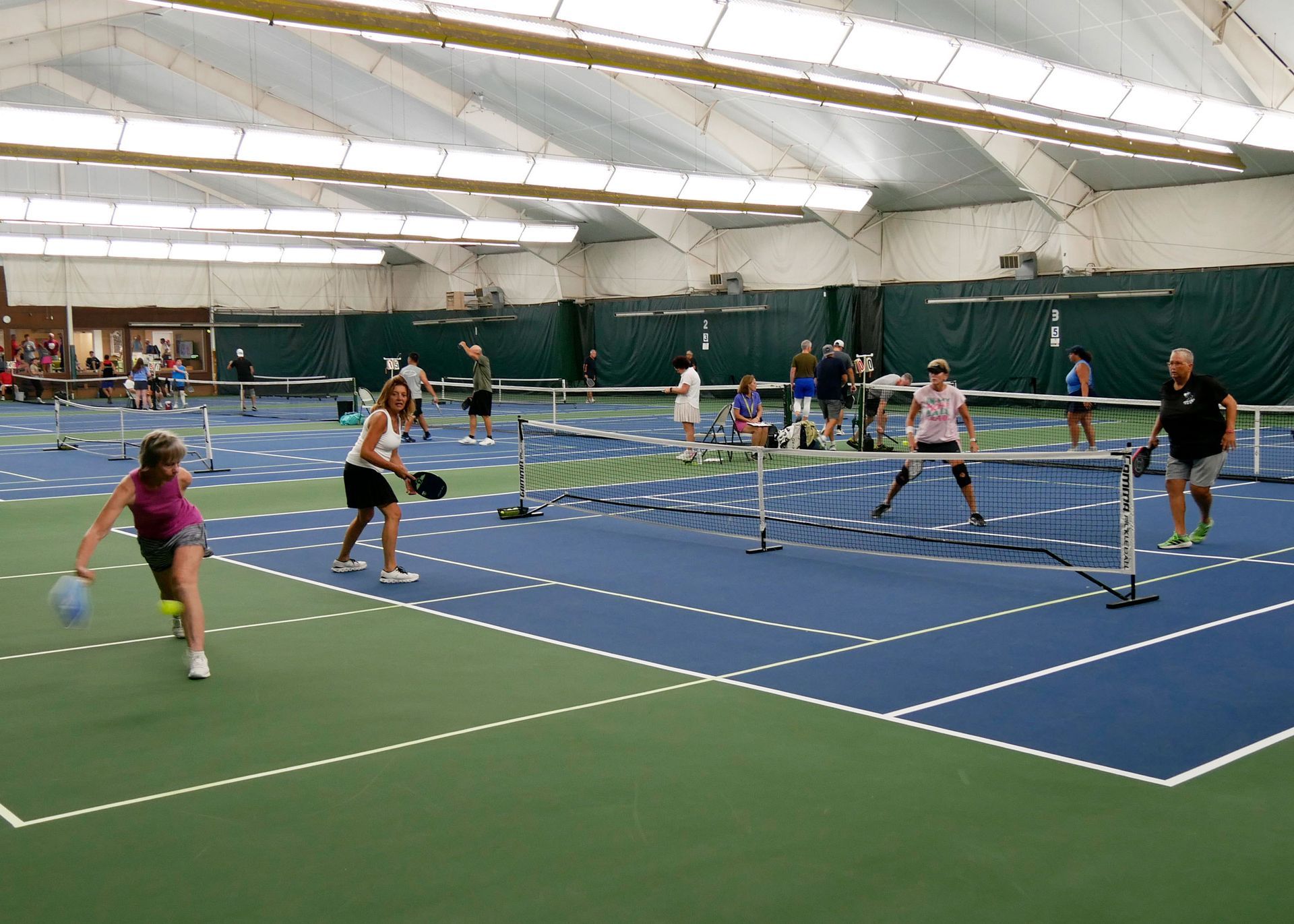 Pickleball doubles teams playing.