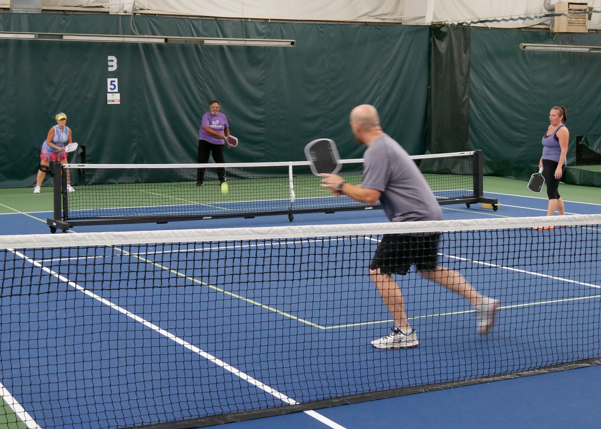 Pickleball doubles teams playing.