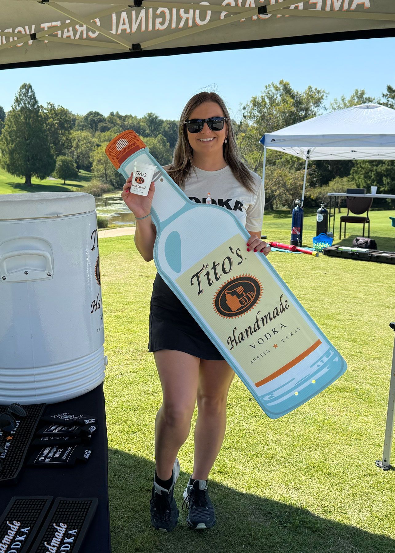 The Tito’s bartender poses for a photo with a large cutout of a Tito’s Handmade Vodka bottle.