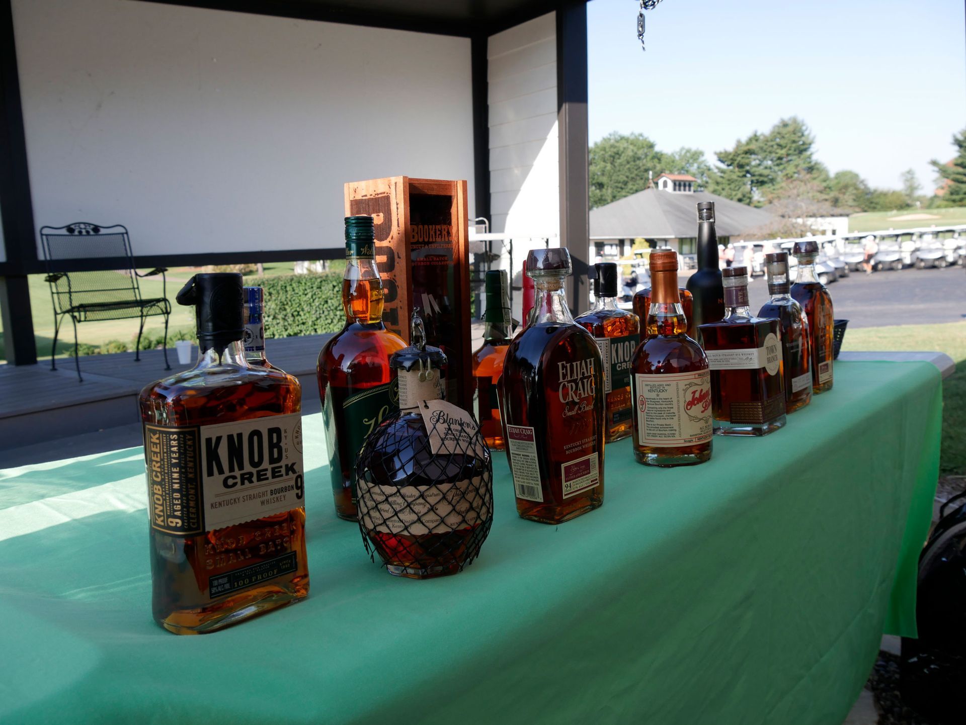 The bottles of bourbon on a table with a green tablecloth. The bottles were available to win in the bourbon pull.