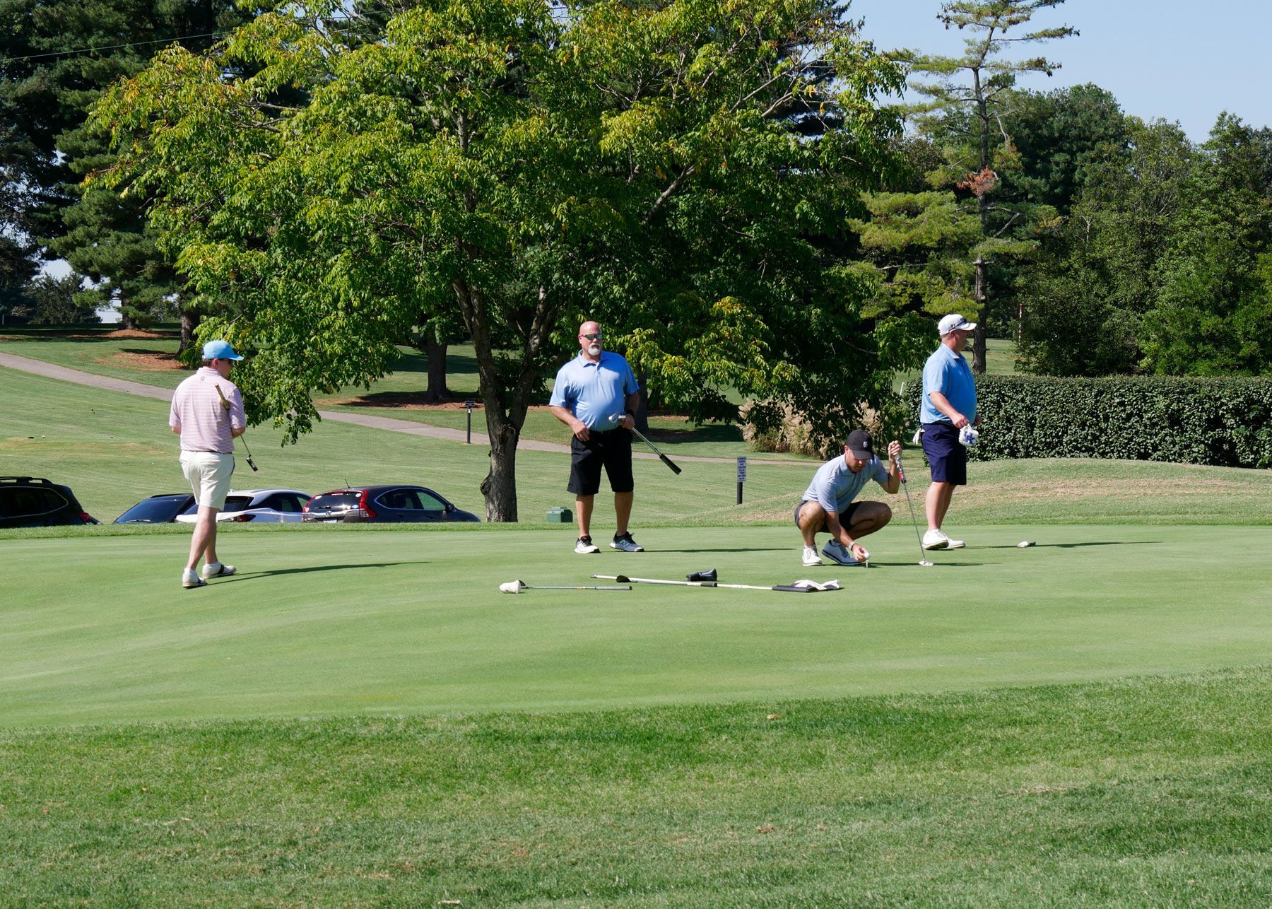Four men on a putting green.