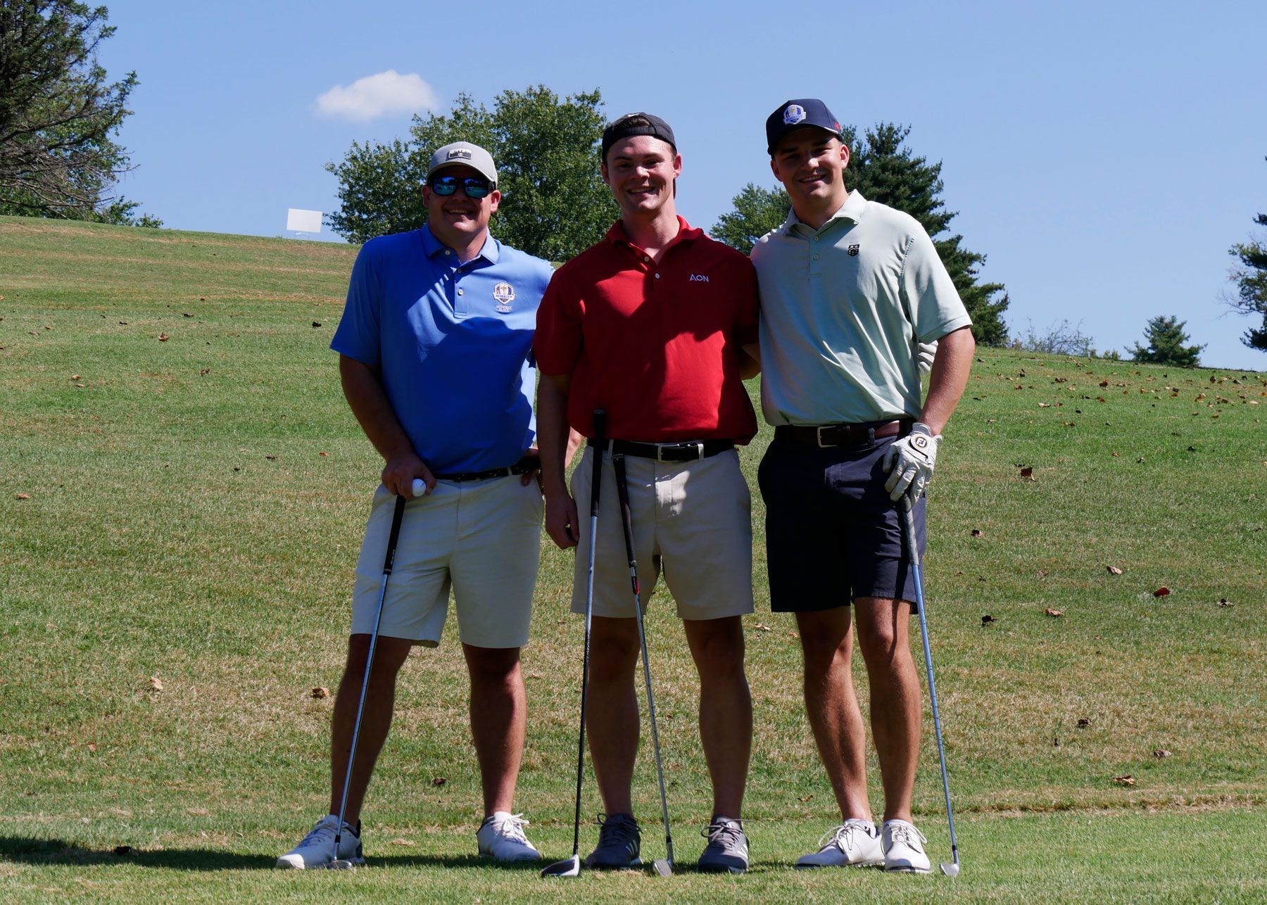 Three men posing for a photo on the golf course.