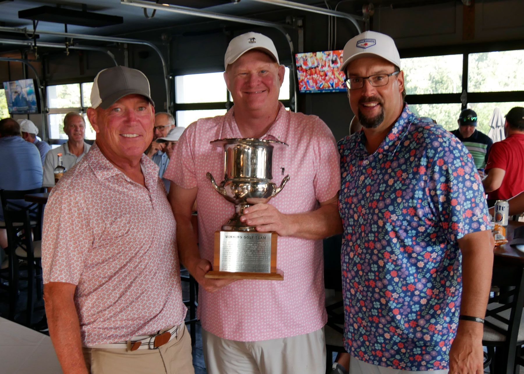 Doug Voss and team pose for a photo with the golf trophy.