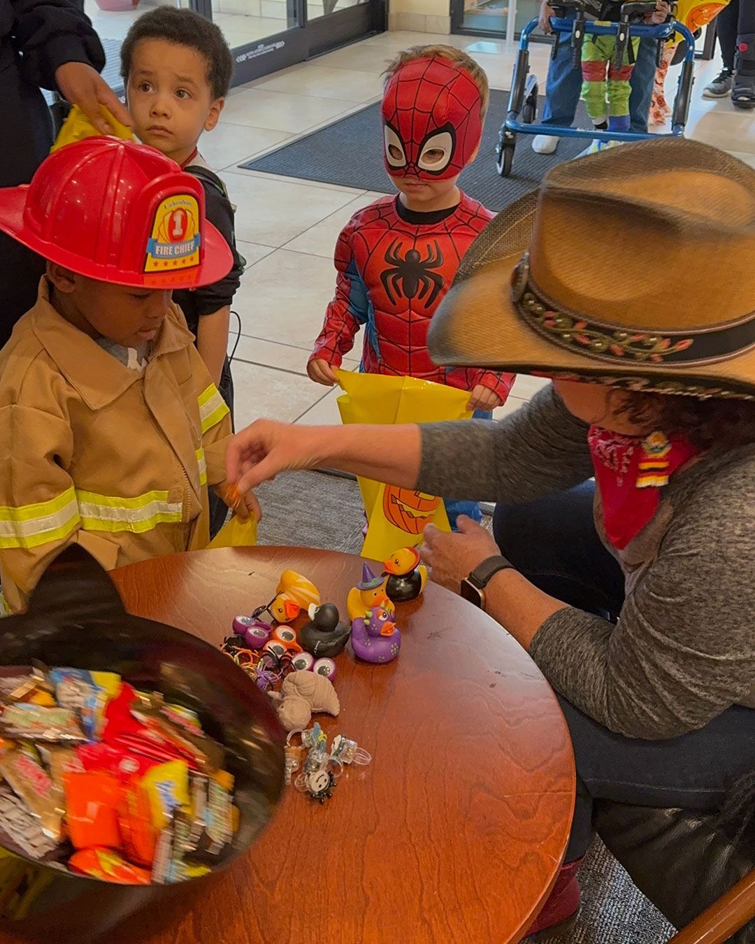 Spiderman and a fireman get treats from Cowgirl Kirsten.