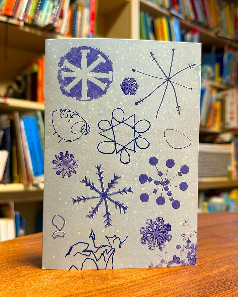 Portrait of the 2025 VIPS Holiday Card sitting on a table in the library.