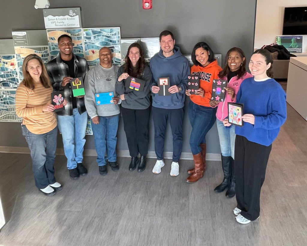 Volunteers from the NCAA PR team pose for a photo with the cards they made.