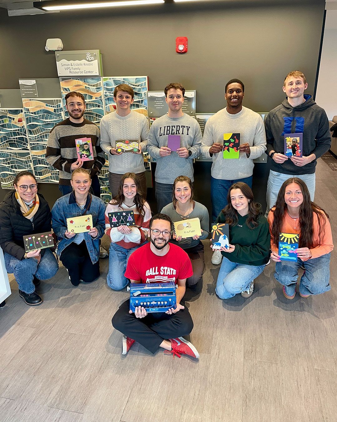 The volunteer group from Mercy Road Church poses for a photo with the cards and books they made during their visit to the Family Resource Center.