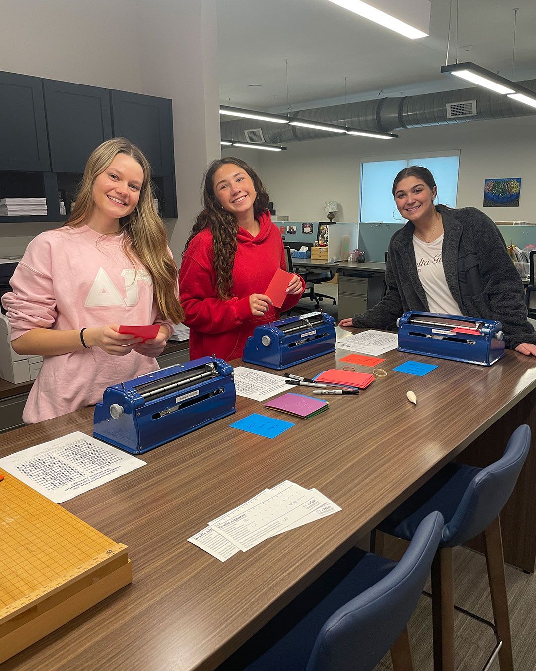 Three Delta Gammas make braille card inserts at the FRC.