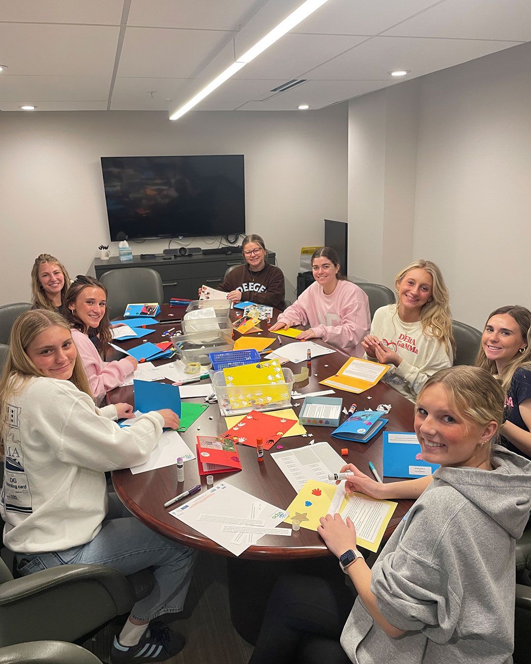 Delta Gammas sit around the conference table in the FRC and make cards.