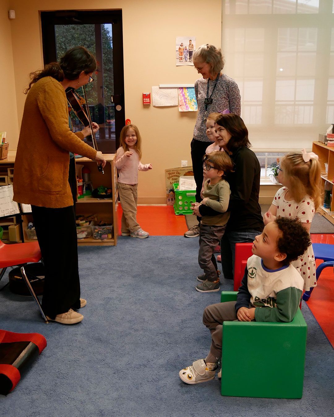 Jannell plays the fiddle for kids in the classroom.
