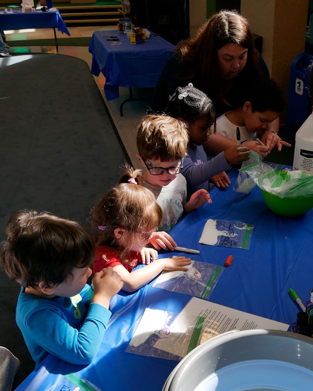 Kids are writing their names on bags of slime to take home.