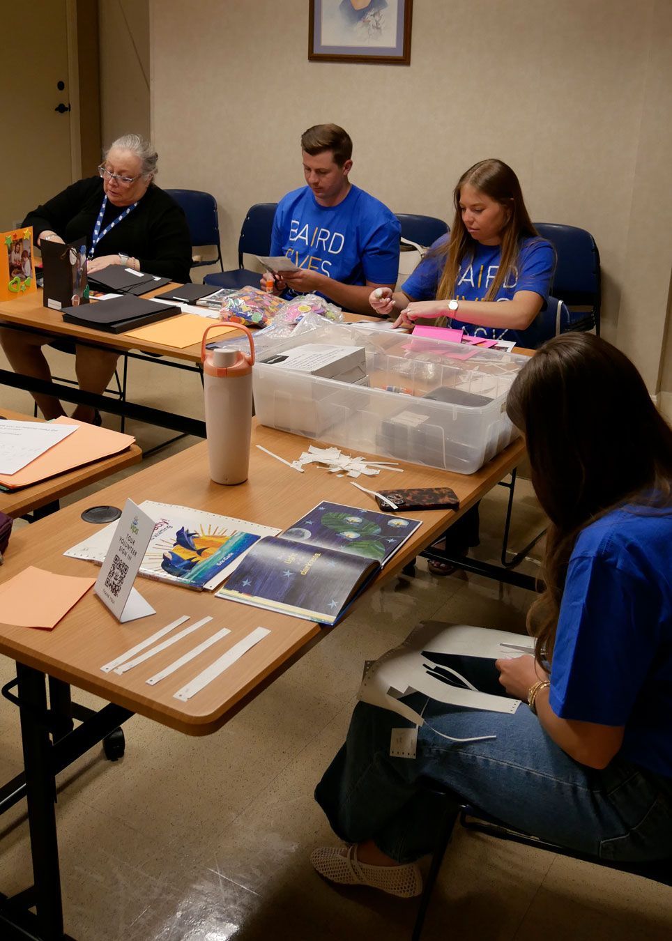 Baird volunteers make thank you cards and cut out braille translations.