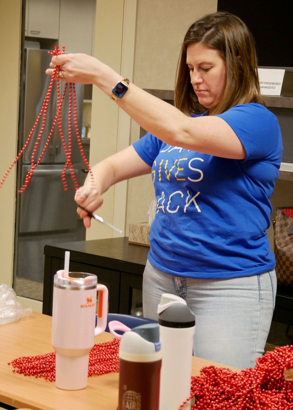 A Baird volunteer cuts bead strings used on octopus lights.