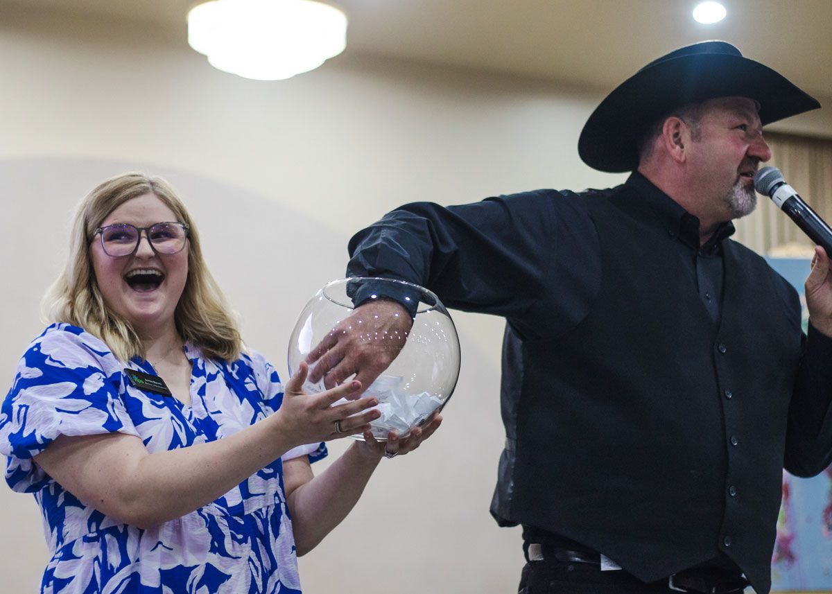 Auctioneer Shaun Logsdon pulls the Golden Ticket winning name from a fish bowl held by Justine Aycock.