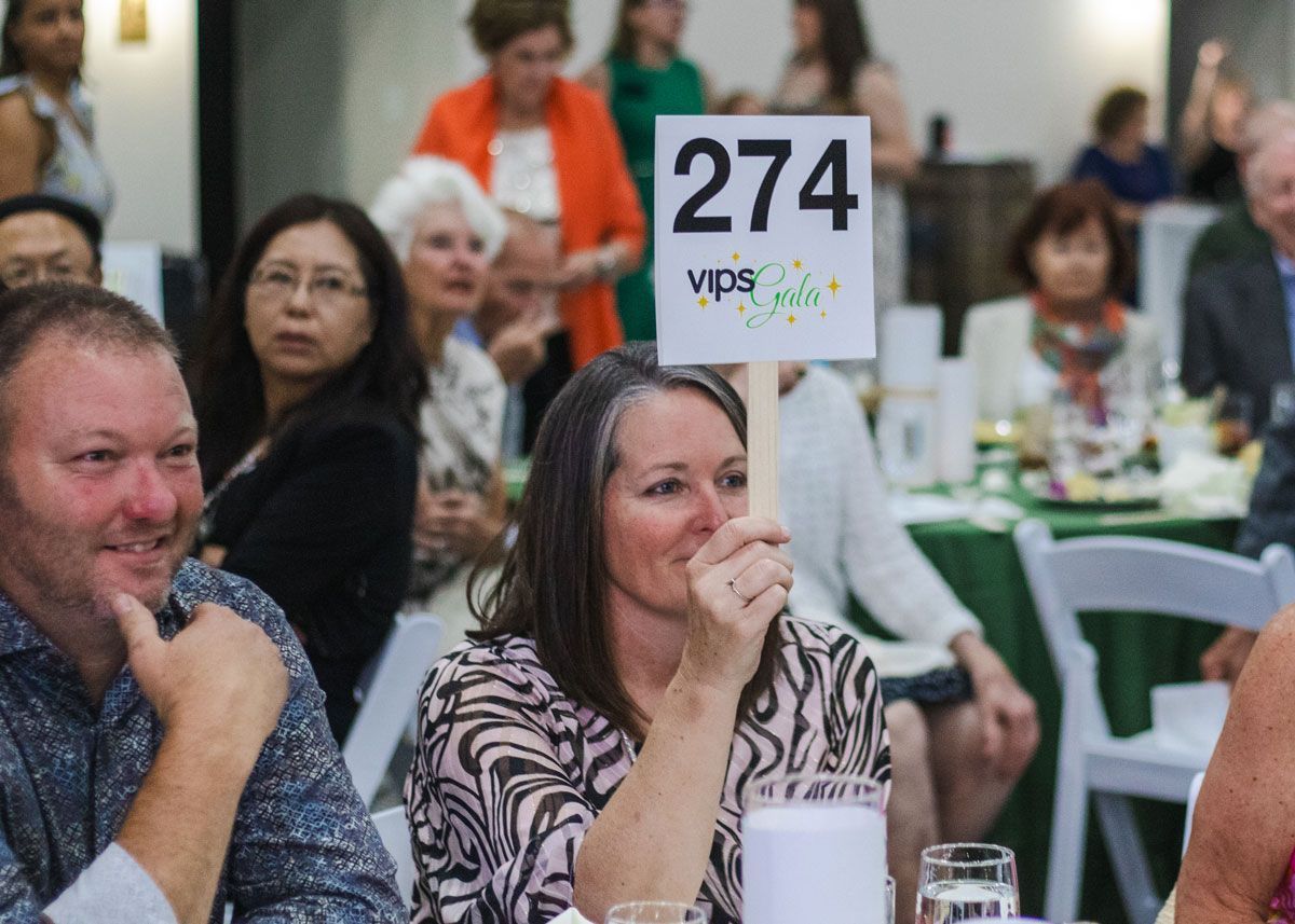 A woman holds up an auction paddle during the Gala.