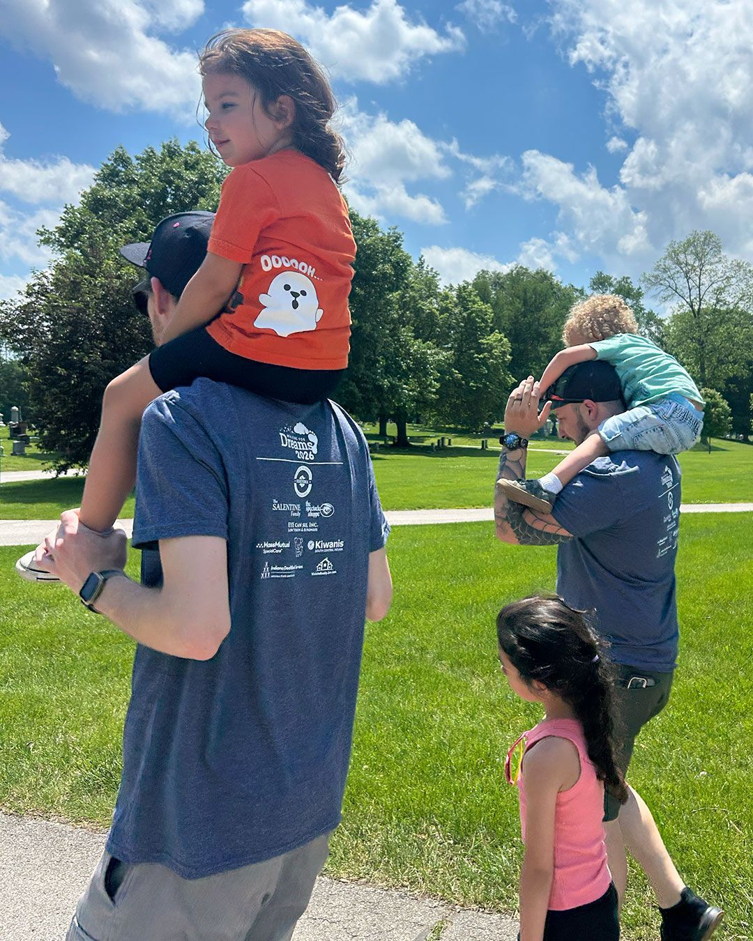 Children ride on their fathers' shoulders during Walking for Dreams.