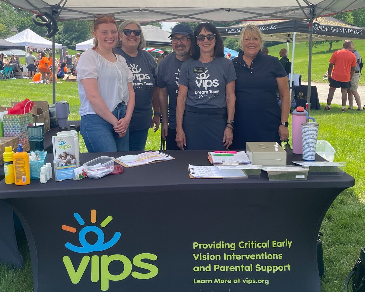 The VIPS Team: Caitlyn, Michelle, David, Rita, and Diane pose for a photo behind the registration table at Walking for Dreams.