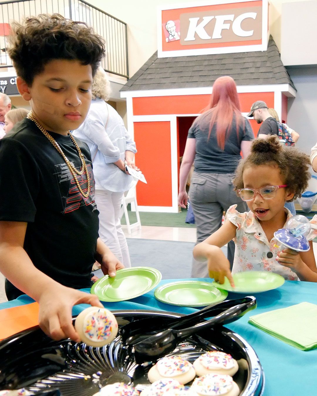 Kendall's big brother selects a cookie for her.