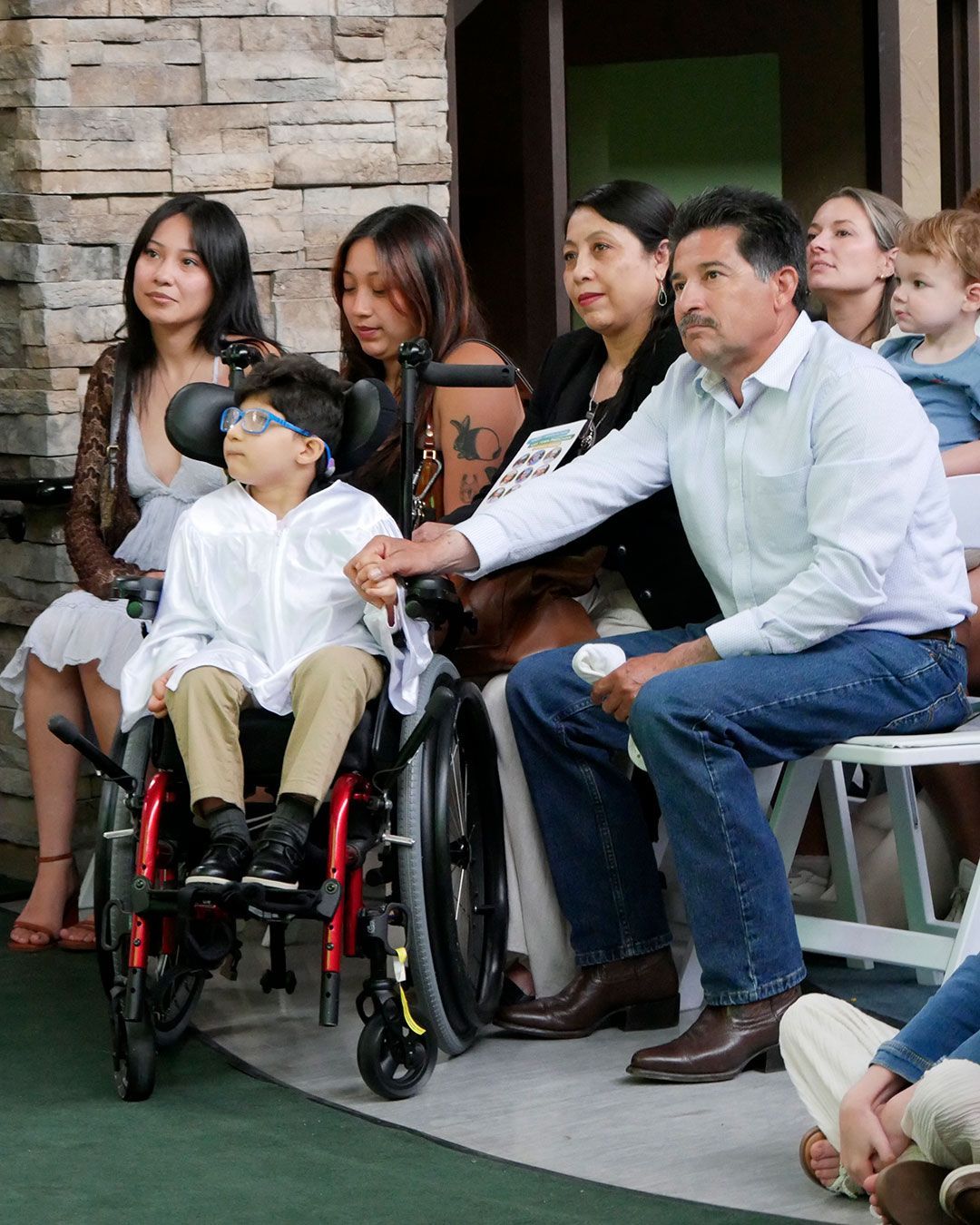 A graduate and his family watch the presentation.