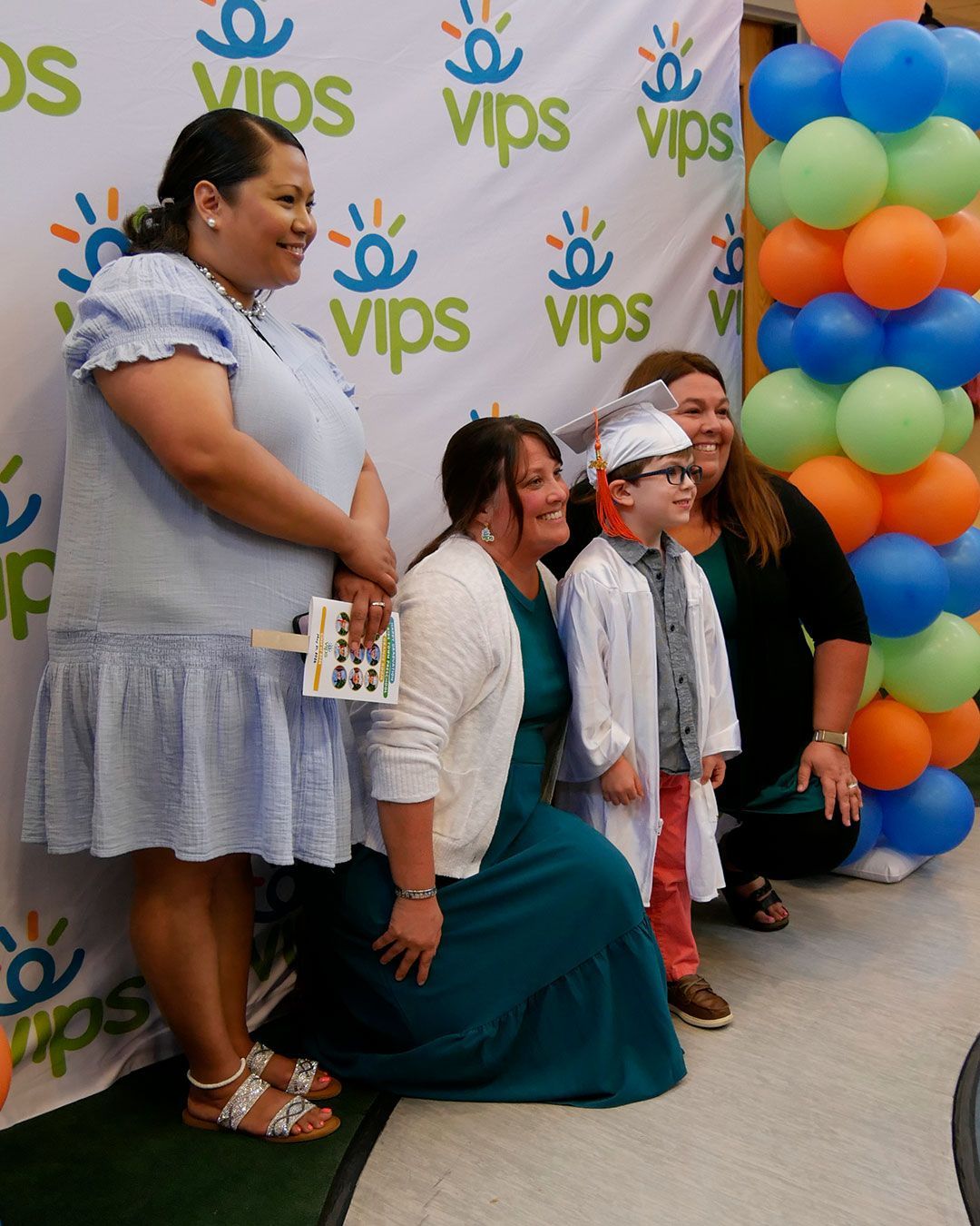 A graduate poses for a photo with his teachers.