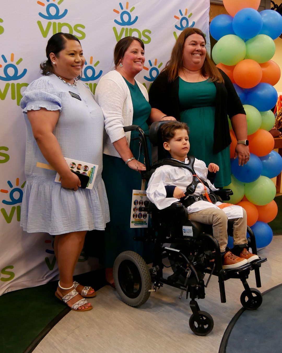 A graduate poses for a photo with his teachers.