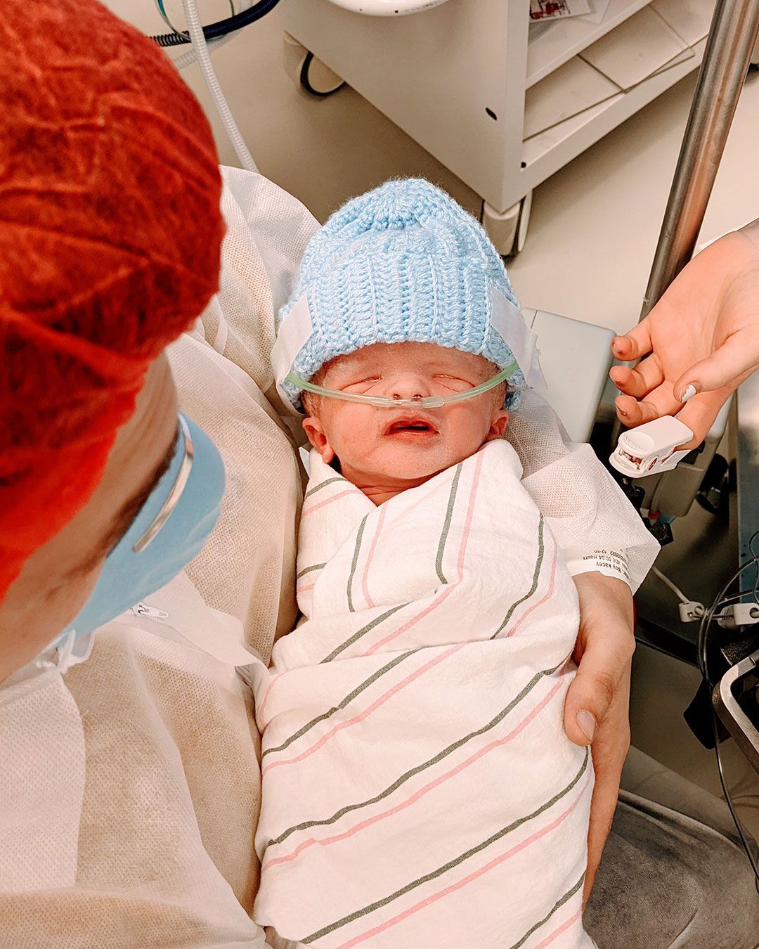 Kacey is holding a newborn Sonny in the hospital.