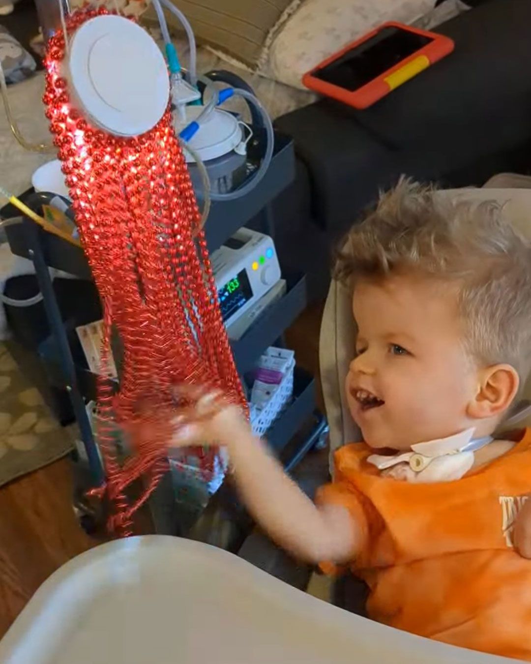 Sonny is playing with the beads on an octopus light.