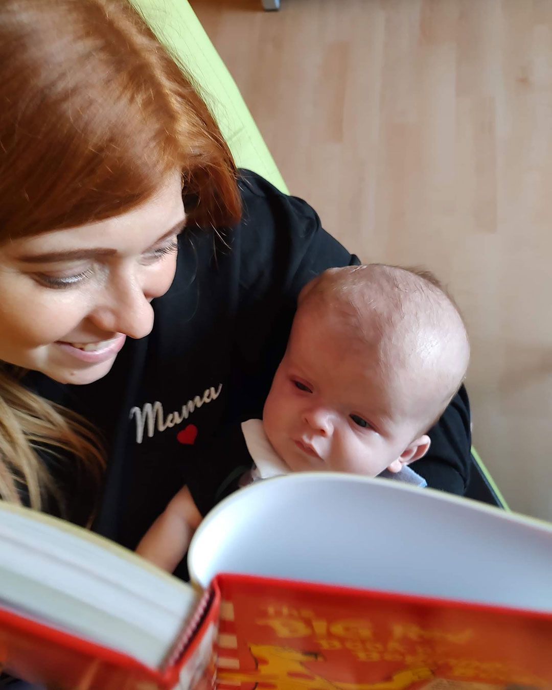 Kacey is holding Sonny and reading to him.