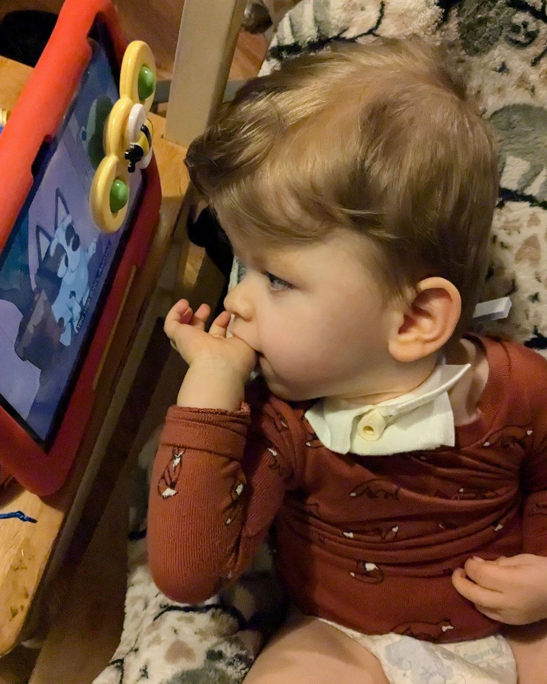 Sonny is intently watching a Bluey video on an iPad.