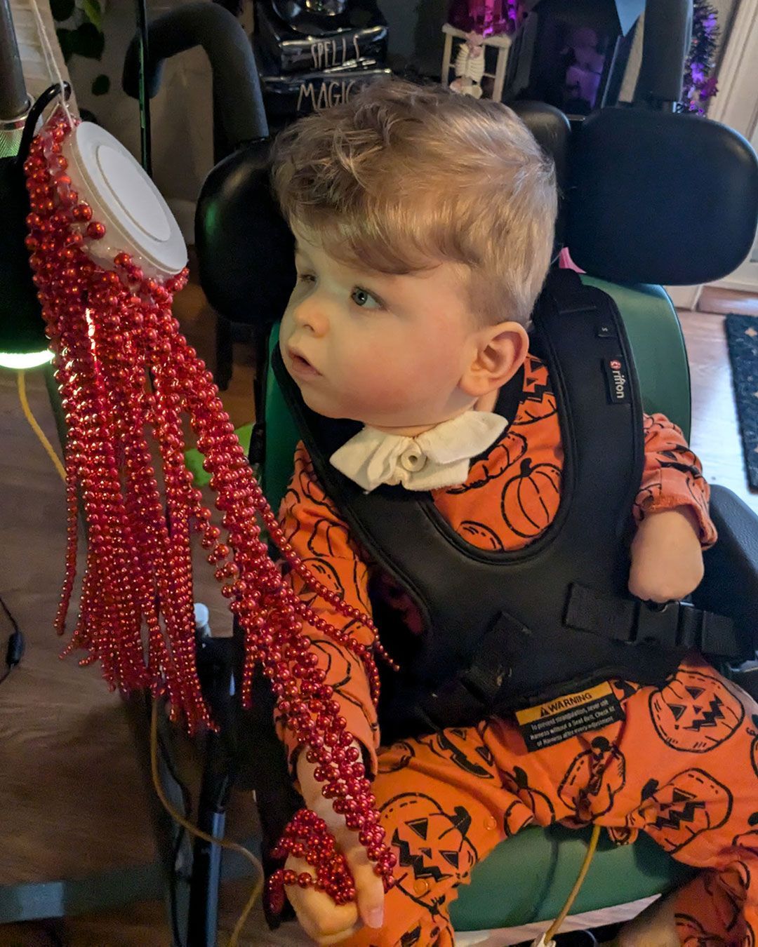 Sonny is playing with the beads on an octopus light.