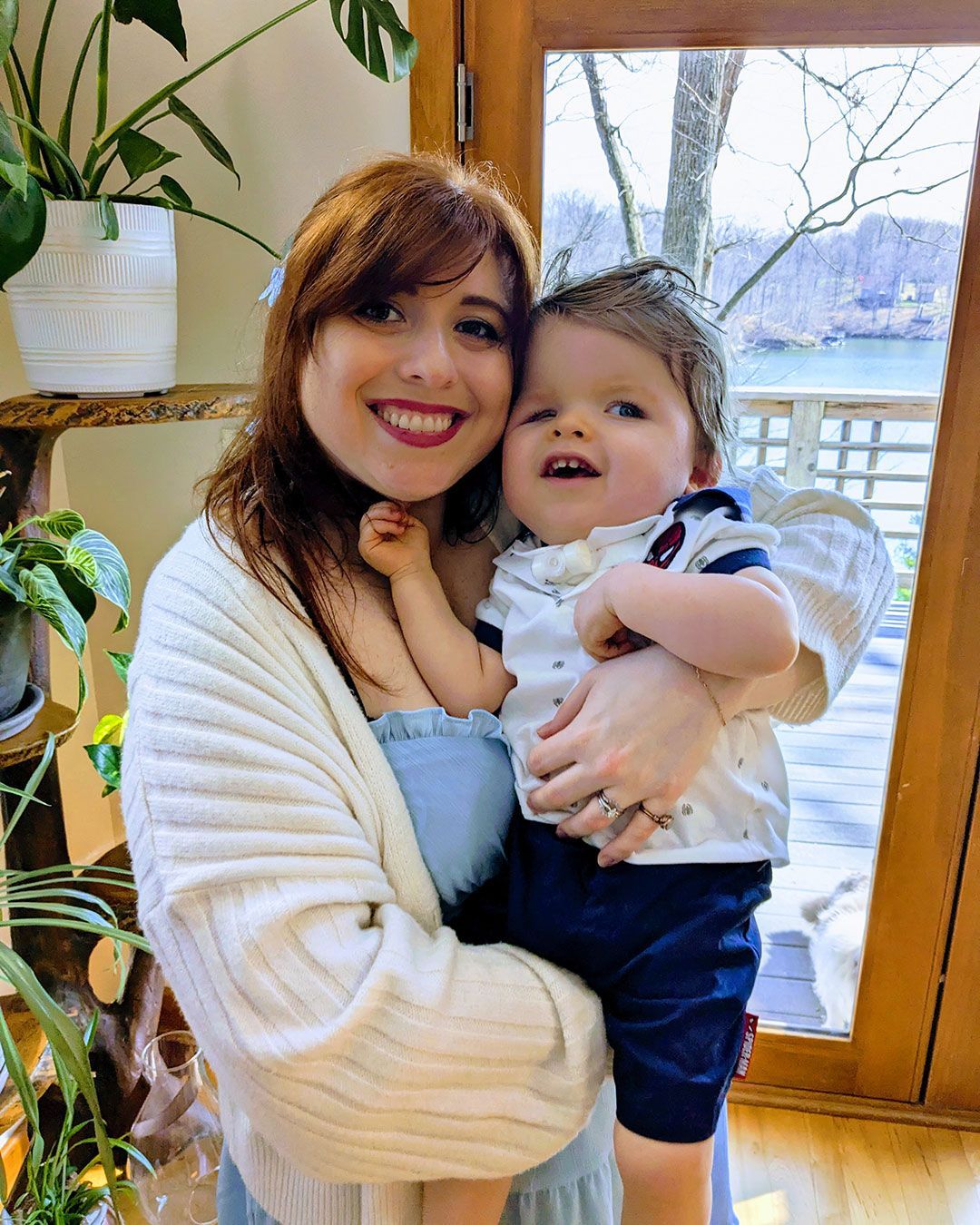Kacey is holding Sonny and they are smiling and posing for a photo.