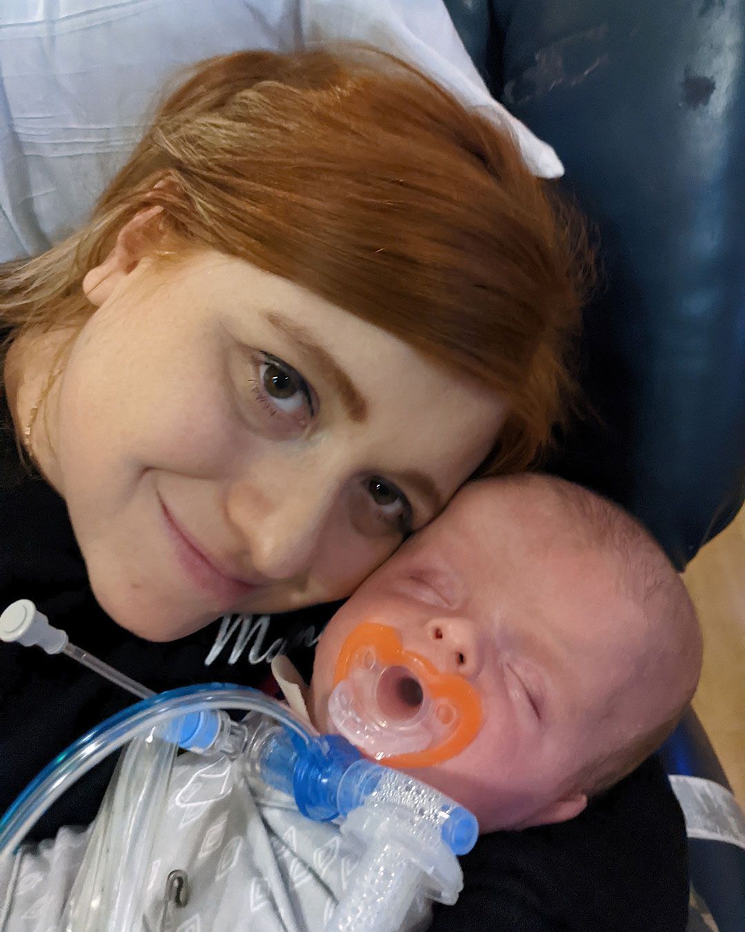 Kacey is smiling and holding an infant Sonny.