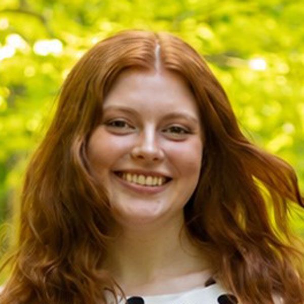 Woman with glasses smiling at the camera.
