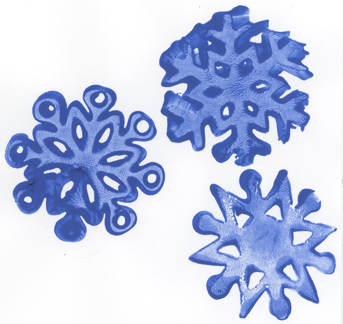 Three child-made snowflakes created a shaped stamp and blue ink.