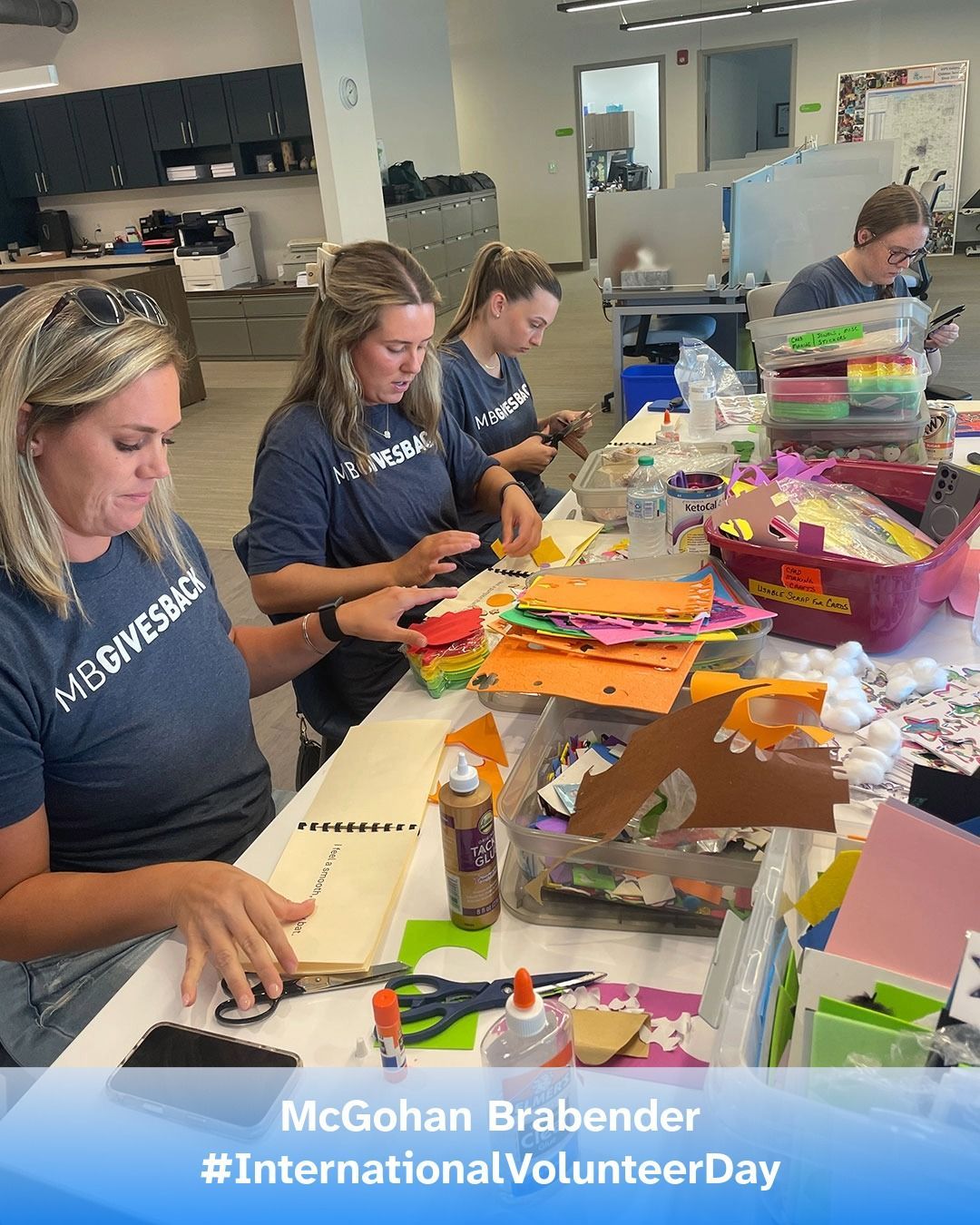 Volunteers from McGohan Brabender assemble books in the VIPS Indiana office.