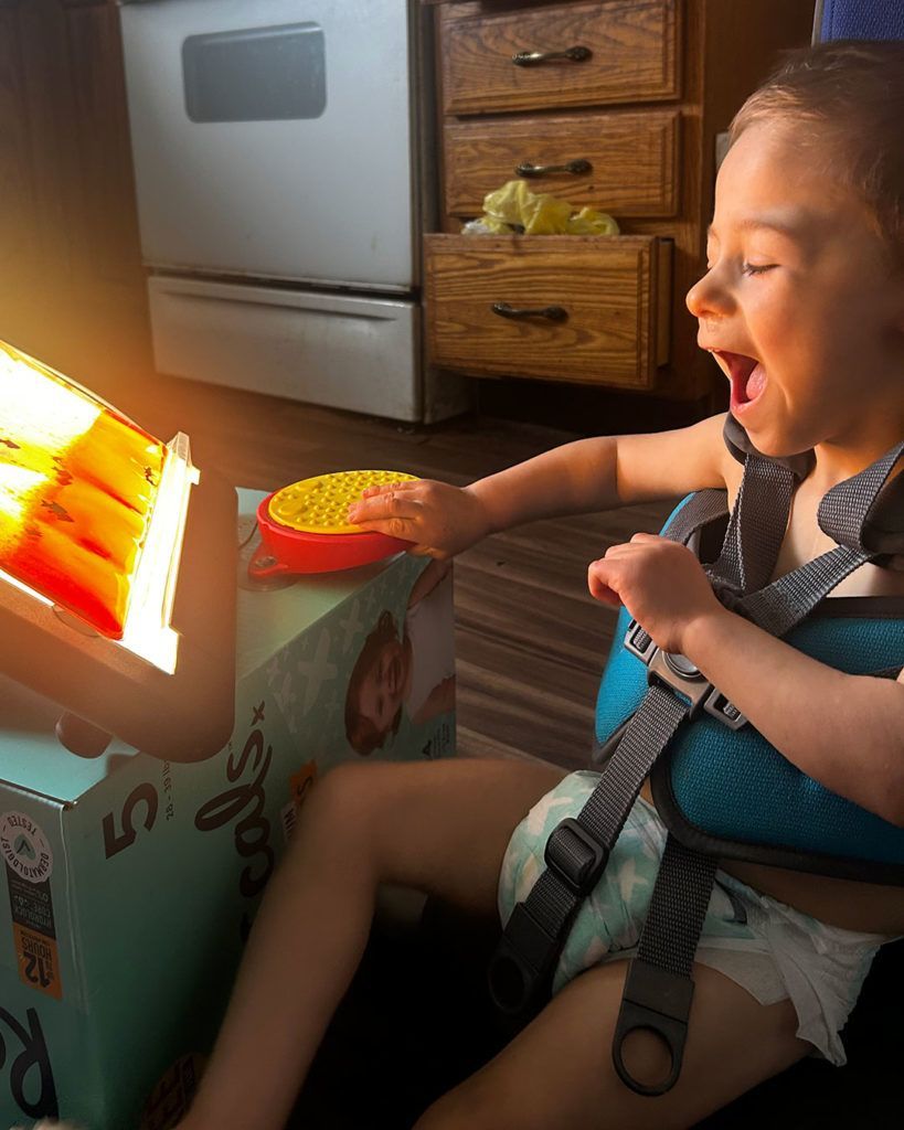 Elliot is laughing and using his light box.
