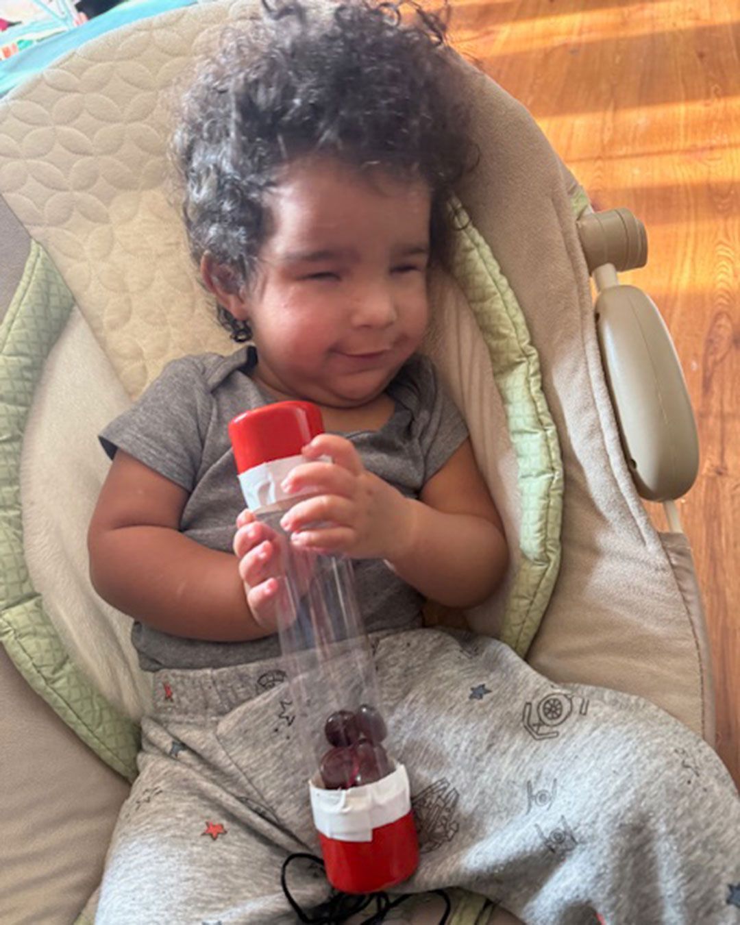 Ezra is holding a shaker tube and smiling.