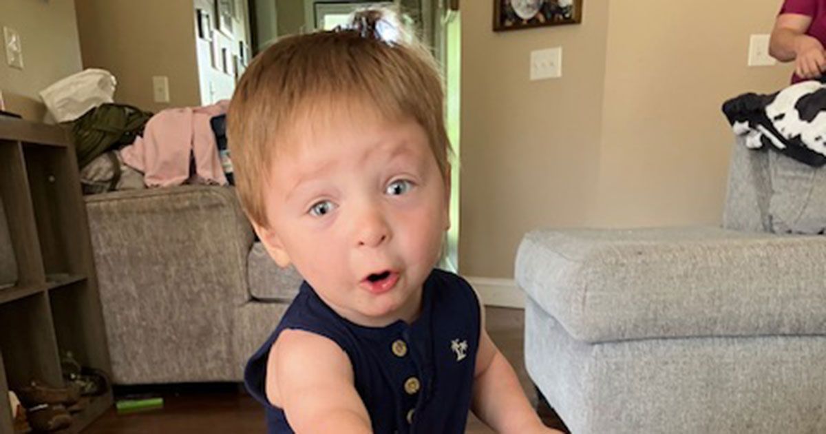 Luke is standing in the living room and posing for a photo.