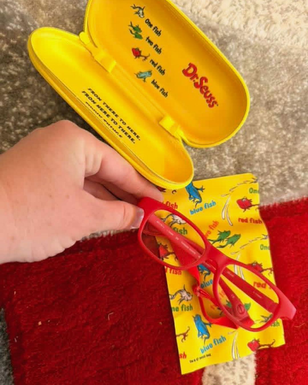 Bethany is holding Wilder's red glasses and Dr. Seuss glasses case.
