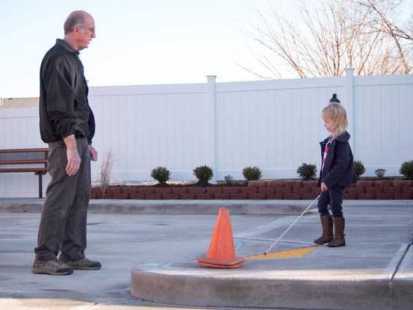 Certified Orientation and Mobility Specialist instructing young child how to navigate their environment.