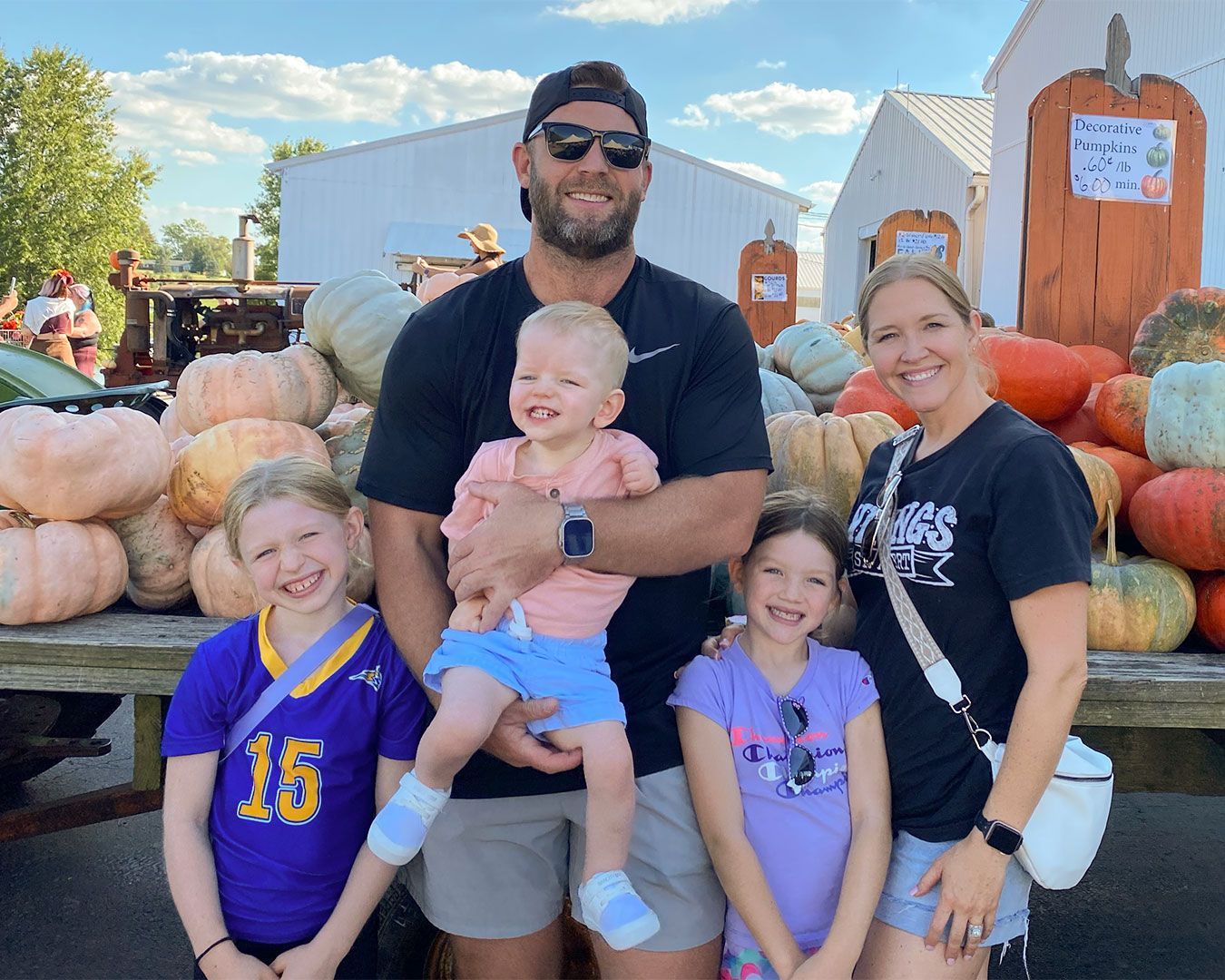 Wells and his family pose for a photo in front of a trailer full of pumpkins.