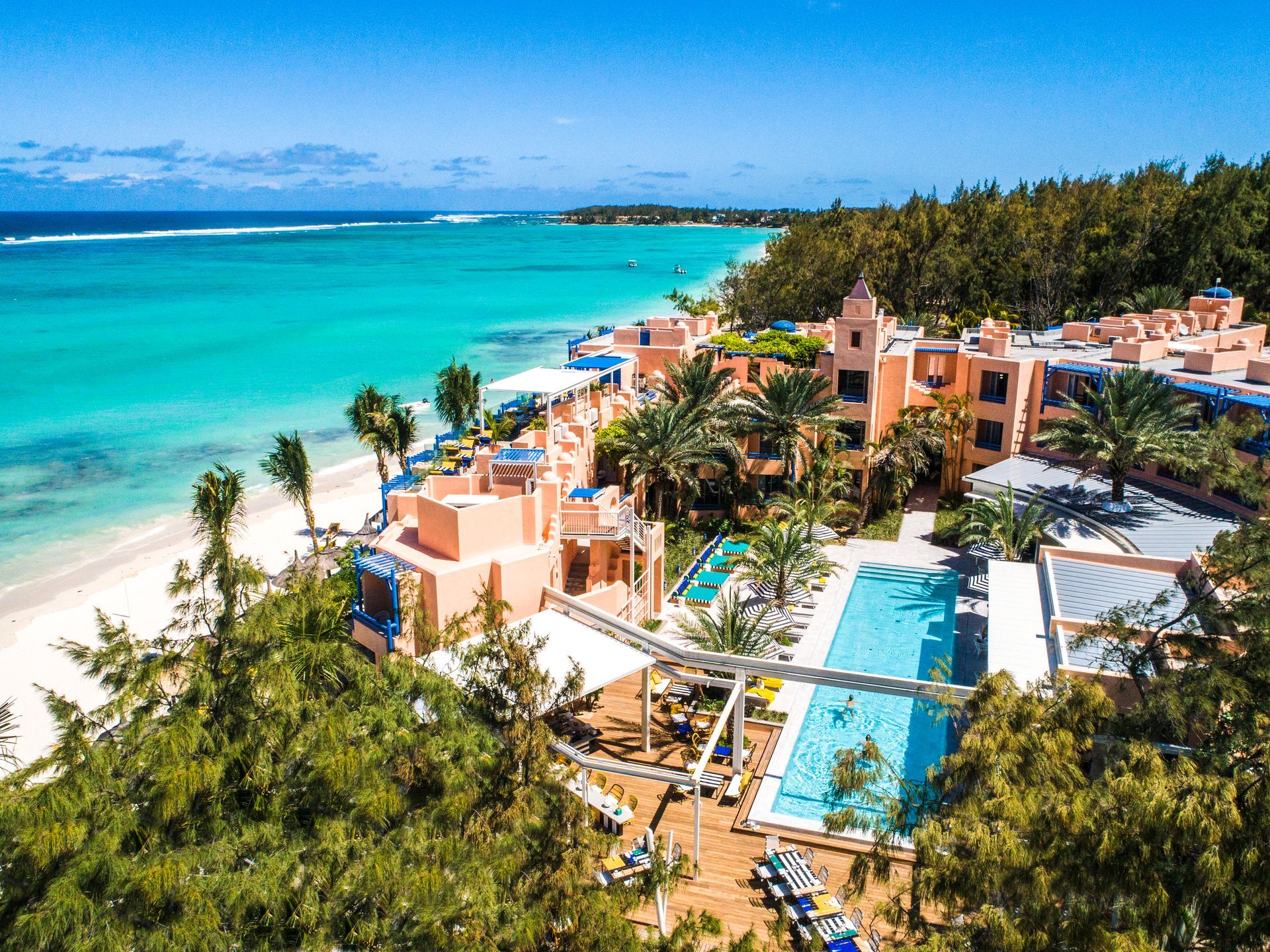 Tropical beachfront of Salt of Palmar with turquoise ocean, palm trees, and a pool beside sandy shore