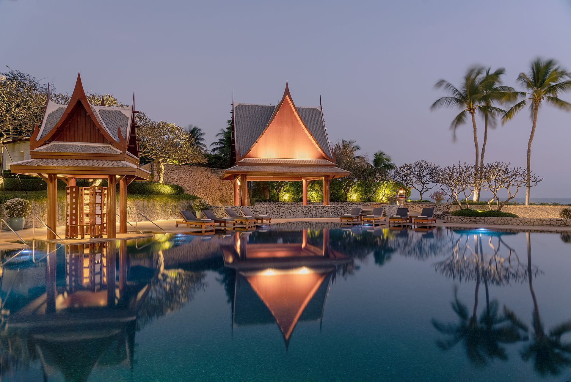 A large swimming pool with a pavilion in the background