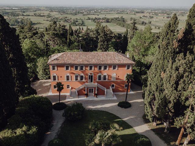 Aerial view of an Italian red-brick building surrounded by dense green forest and trees.