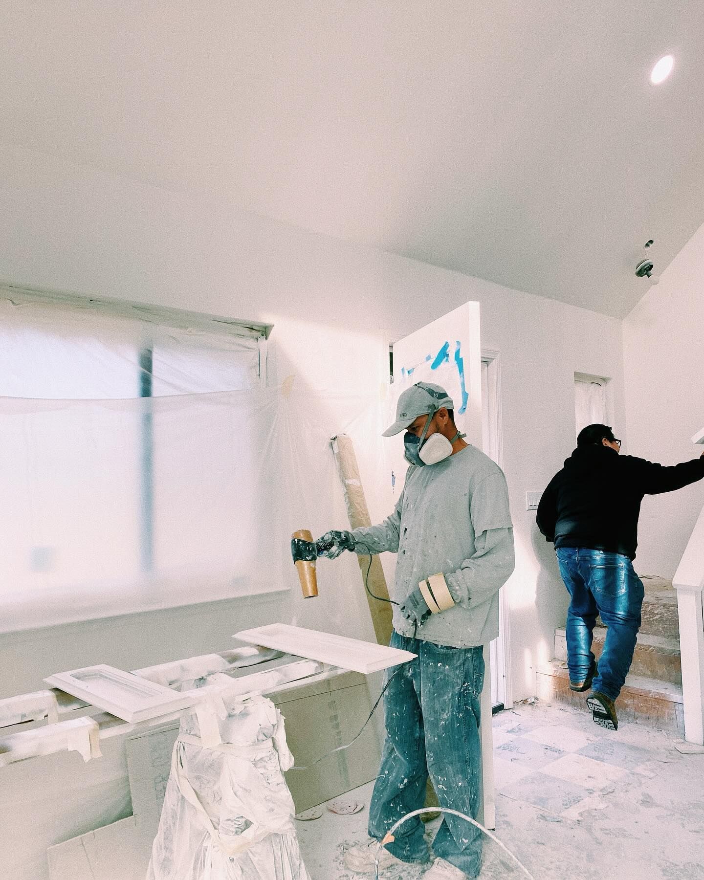 a man wearing a mask is spray painting a wall