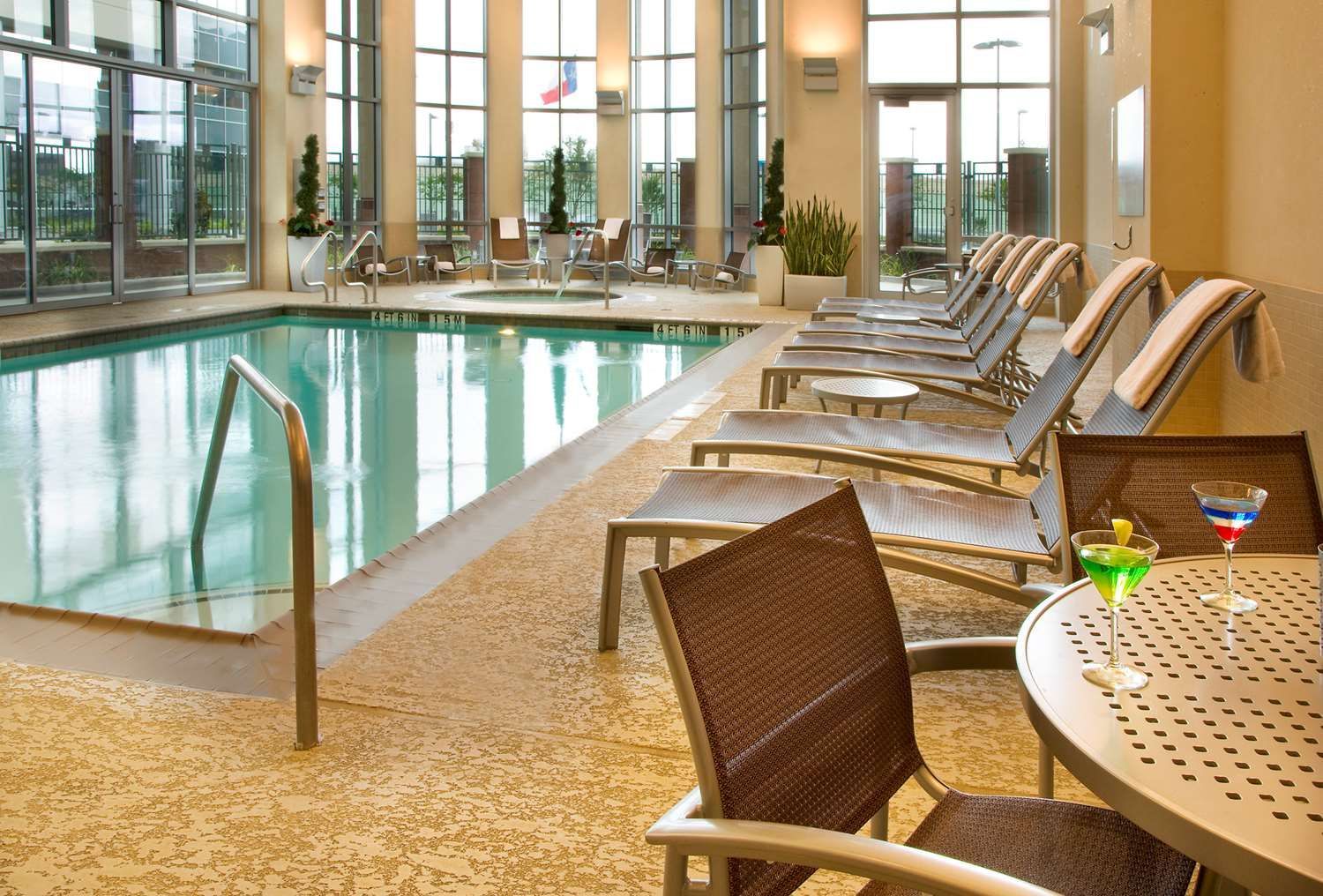 A swimming pool with a table and chairs in front of it
