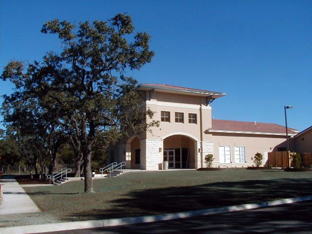 A large building with a red roof and a tree in front of it
