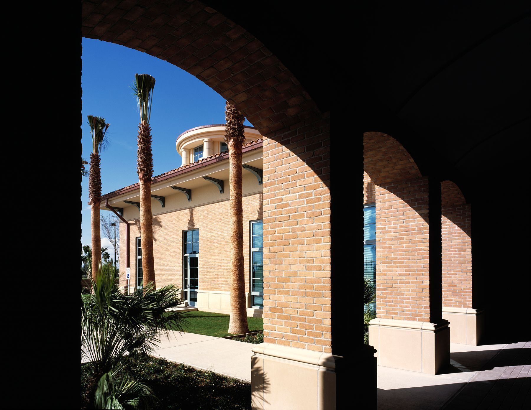 A brick building with palm trees in front of it